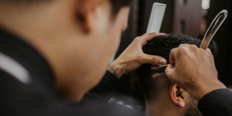 Barber performing men's fade modern hair cut